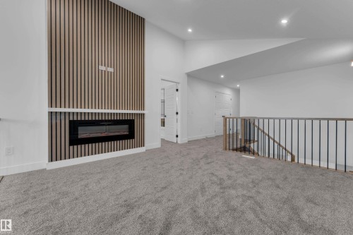 Accent wall featuring vertical wood paneling and a linear electric fireplace - 236 Linden Loop, Leduc, AB 