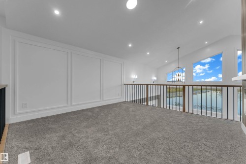 Loft space featuring a vaulted ceiling with recessed lighting, carpet flooring, decorative wall molding, and a metal and wood-finish railing - 236 Linden Loop, Leduc, AB 