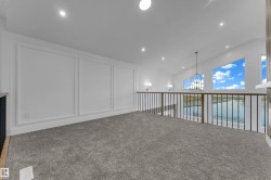 Loft space featuring a vaulted ceiling with recessed lighting, carpet flooring, decorative wall molding, and a metal and wood-finish railing - 