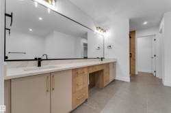 Dual vanity with integrated sinks, white countertop, wood-finish cabinetry, and matte black fixtures - 