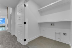 Laundry area featuring two built-in shelves, tile flooring, and clean white walls - 