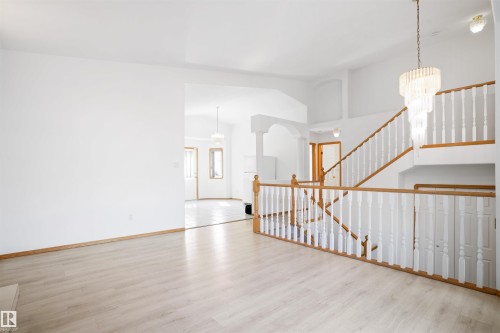 Vaulted ceilings, wood-finish flooring, two-story chandelier, and wood-finish banisters with white balusters - 2915 151A Avenue Nw, Edmonton, AB 