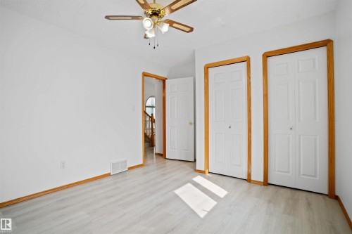 Hard-surface flooring, multiple bi-fold closet doors, wood-finish trim and door frames, ceiling fan with integrated lighting - 2915 151A Avenue Nw, Edmonton, AB 