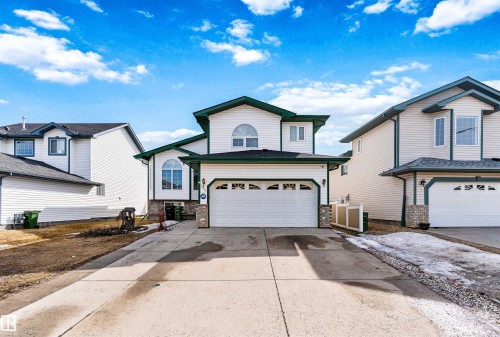 Attached two-car garage with overhead door and transom window accents - 2915 151A Avenue Nw, Edmonton, AB 