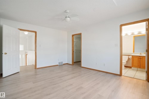 Light wood-finish flooring with white walls and wood trim - 2915 151A Avenue Nw, Edmonton, AB 