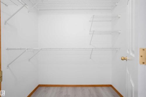 White wire shelving system with multiple shelves, wood-finish flooring, and white walls - 2915 151A Avenue Nw, Edmonton, AB 