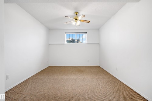 Recessed window with a light-colored frame, light-toned wall-to-wall carpeting, and a ceiling fan with integrated lighting - 2915 151A Avenue Nw, Edmonton, AB 