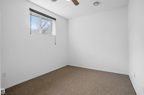 White painted walls, carpet flooring, a single window, and a ceiling fan - 2915 151A Avenue Nw, Edmonton, AB 
