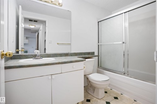 Single vanity with integrated sink, white cabinetry, and wall-mounted mirror - 2915 151A Avenue Nw, Edmonton, AB 