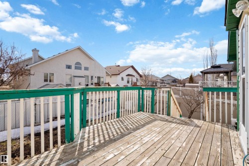 Expansive wood deck with a white and green railing, providing a private outdoor area - 2915 151A Avenue Nw, Edmonton, AB 