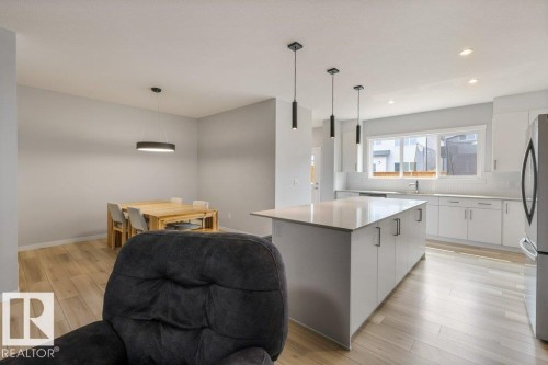 Contemporary kitchen and dining area featuring light wood-finish flooring - 7113 177A Avenue Nw, Edmonton, AB - Indoor Photo Showing Kitchen With Upgraded Kitchen