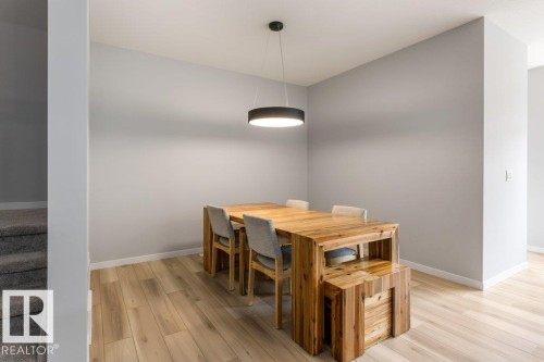Dining area featuring light wood-finish flooring, a contemporary ceiling light fixture, and neutral wall tones - 7113 177A Avenue Nw, Edmonton, AB - Indoor Photo Showing Dining Room