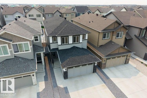 Modern multi-story home featuring a dark shingle roof, light gray siding, and contrasting black trim - 7113 177A Avenue Nw, Edmonton, AB - Outdoor