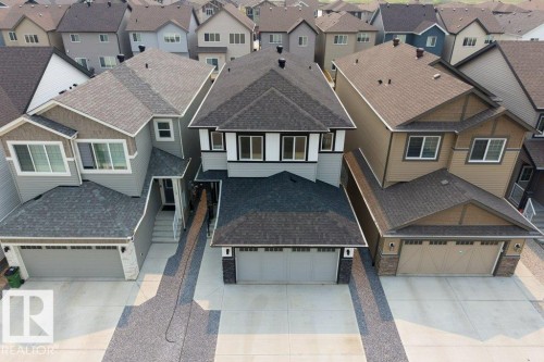 Modern two-story residence featuring a two-car garage, dark shingle roof, light gray siding, and white trim accents - 7113 177A Avenue Nw, Edmonton, AB - Outdoor With Facade