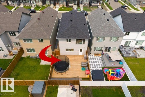 Expansive backyard featuring a wood deck, artificial turf patio area, and mature perimeter fencing - 7113 177A Avenue Nw, Edmonton, AB - Outdoor