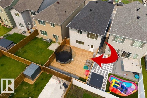Spacious backyard featuring a wood deck, artificial turf, and a paved patio area - 7113 177A Avenue Nw, Edmonton, AB - Outdoor
