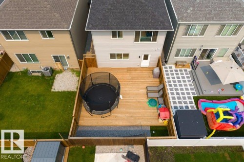 Private backyard featuring a spacious wooden deck with dark stone accents - 7113 177A Avenue Nw, Edmonton, AB - Outdoor With Exterior