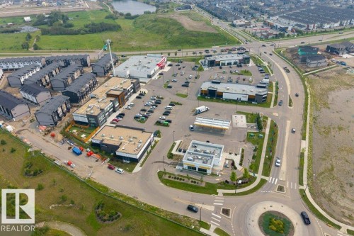 Aerial perspective showcasing a multi-building complex including residential townhomes and commercial structures - 7113 177A Avenue Nw, Edmonton, AB - Other