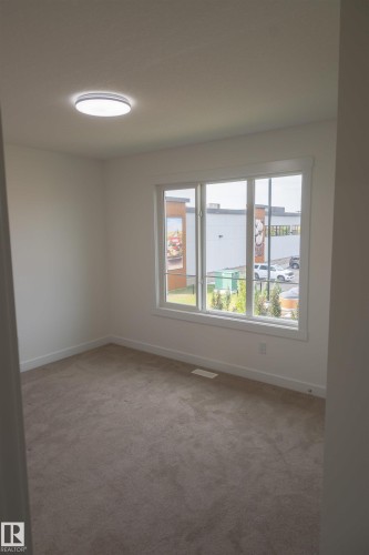 Neutral-toned carpeting, white walls, and a contemporary ceiling light fixture - #64 2710 66 St Sw Sw, Edmonton, AB 