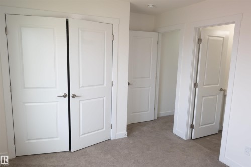 Neutral tone wall paint, carpet flooring, multiple panel doors, and brushed nickel hardware - #64 2710 66 St Sw Sw, Edmonton, AB 