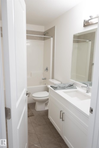 White vanity with integrated sink, chrome faucet, and brushed nickel hardware - #64 2710 66 St Sw Sw, Edmonton, AB 