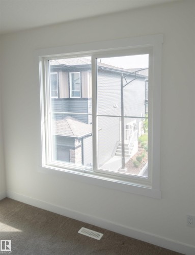 Sliding window with white trim, neutral carpet, and white walls - #64 2710 66 St Sw Sw, Edmonton, AB 