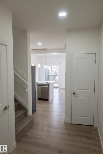 Wood-finish flooring, recessed lighting, white interior doors, and a carpeted staircase - #64 2710 66 St Sw Sw, Edmonton, AB 
