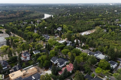 Aerial perspective showcasing a verdant neighborhood with a winding river, abundant mature trees, and a mix of residential properties - 10223 130 Street Nw, Edmonton, AB 