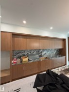 Full-height cabinetry, stone countertops, stone backsplash, recessed lighting, integrated sink - 
