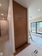 Integrated wood-finish cabinetry with silver-tone hardware, recessed ceiling lighting, and wood-finish flooring - 