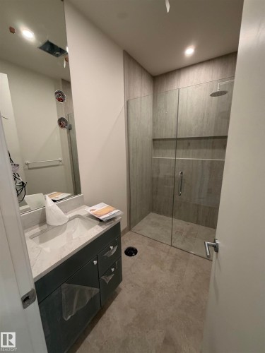 Vanity with a light-toned countertop, under-mount sink, and dark cabinetry - 10223 130 Street Nw, Edmonton, AB 
