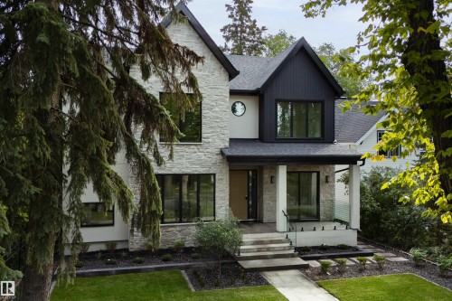 Stone and vertical siding exterior with a covered porch, concrete steps, and a glass-paneled railing - 10223 130 Street Nw, Edmonton, AB 