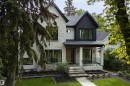 Stone and vertical siding exterior with a covered porch, concrete steps, and a glass-paneled railing - 10223 130 Street Nw, Edmonton, AB 