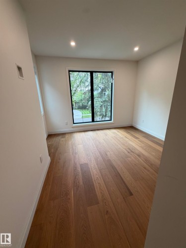 Recessed lighting, wood-finish flooring, and a large window with black trim - 10223 130 Street Nw, Edmonton, AB 