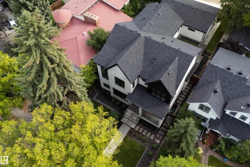 Modern exterior with dark shingle roofing, light-toned stone cladding, and contrasting dark trim accents - 10223 130 Street Nw, Edmonton, AB 