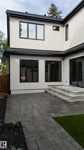 Stucco exterior with black-framed windows, black eaves, and a dark shingle roof - 10223 130 Street Nw, Edmonton, AB 