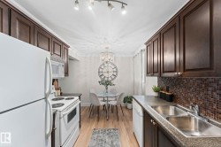 Kitchen featuring dark wood-finish cabinetry, mosaic tile backsplash, and light wood-finish flooring - 
