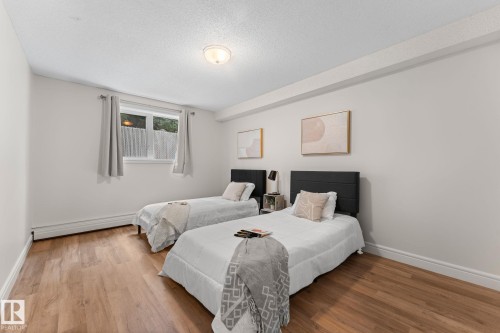 Wood-finish flooring, white walls, and a window with privacy covering - #106 10735 81 Av Nw, Edmonton, AB 