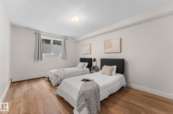 Wood-finish flooring, white walls, and a window with privacy covering - 