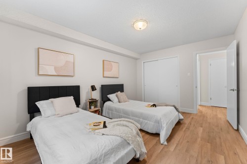 Wood-finish flooring with white trim, recessed lighting, and a closet with sliding doors - #106 10735 81 Av Nw, Edmonton, AB 