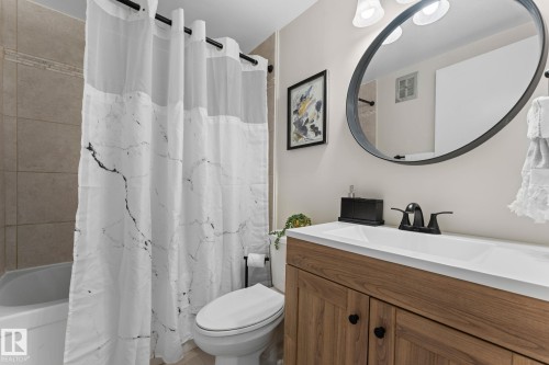 Wood-finish vanity with a white countertop and undermount sink - #106 10735 81 Av Nw, Edmonton, AB 