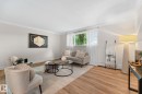 Wood-finish flooring, crown molding, and a large window with natural light - #106 10735 81 Av Nw, Edmonton, AB 