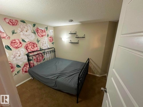 Carpeted flooring with a decorative accent wall and ceiling-mounted lighting - 8715 11 Avenue Sw, Edmonton, AB 