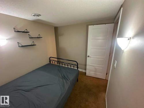 Textured wall-to-wall carpeting, recessed ceiling lighting, and a paneled door - 8715 11 Avenue Sw, Edmonton, AB 