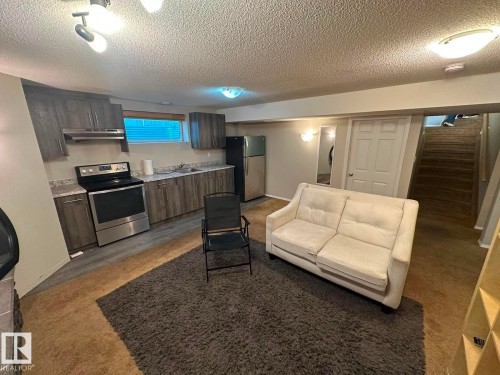 Kitchenette with stainless steel appliances, wood-finish flooring, and track lighting - 8715 11 Avenue Sw, Edmonton, AB 