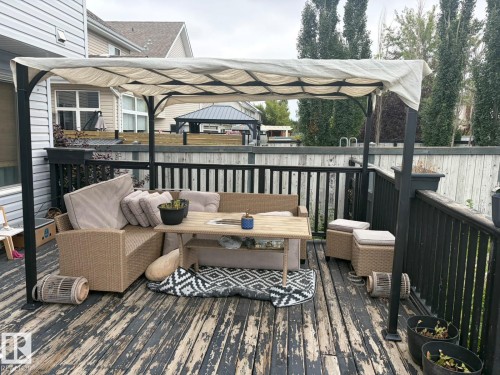 Expansive outdoor deck featuring wood flooring and black railings - 8715 11 Avenue Sw, Edmonton, AB 
