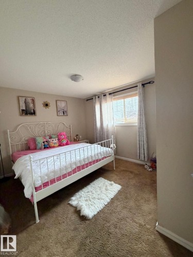 Carpeted flooring, window with blinds, and flush-mount ceiling light - 8715 11 Avenue Sw, Edmonton, AB 