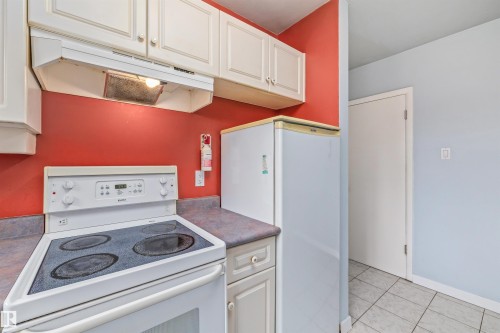 Kitchen featuring white cabinetry, a white electric range with a built-in range hood, and a compact white refrigerator - 13320 123 Street Nw, Edmonton, AB - Indoor Photo Showing Kitchen