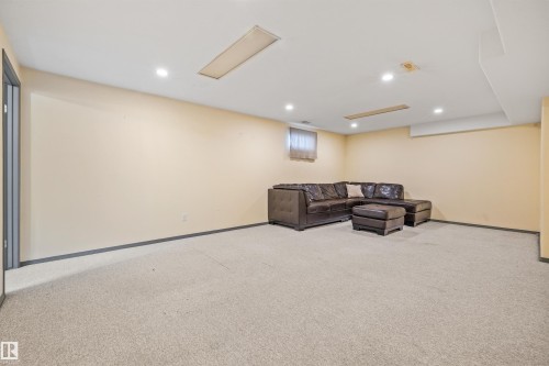 Spacious room featuring neutral carpeting, recessed lighting, and a drop ceiling with integrated lighting elements - 13320 123 Street Nw, Edmonton, AB - Indoor Photo Showing Basement
