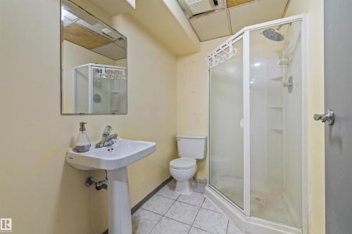 Bathroom featuring a pedestal sink, wall-mounted mirror, and a corner shower enclosure with a rain showerhead - 13320 123 Street Nw, Edmonton, AB - Indoor Photo Showing Bathroom